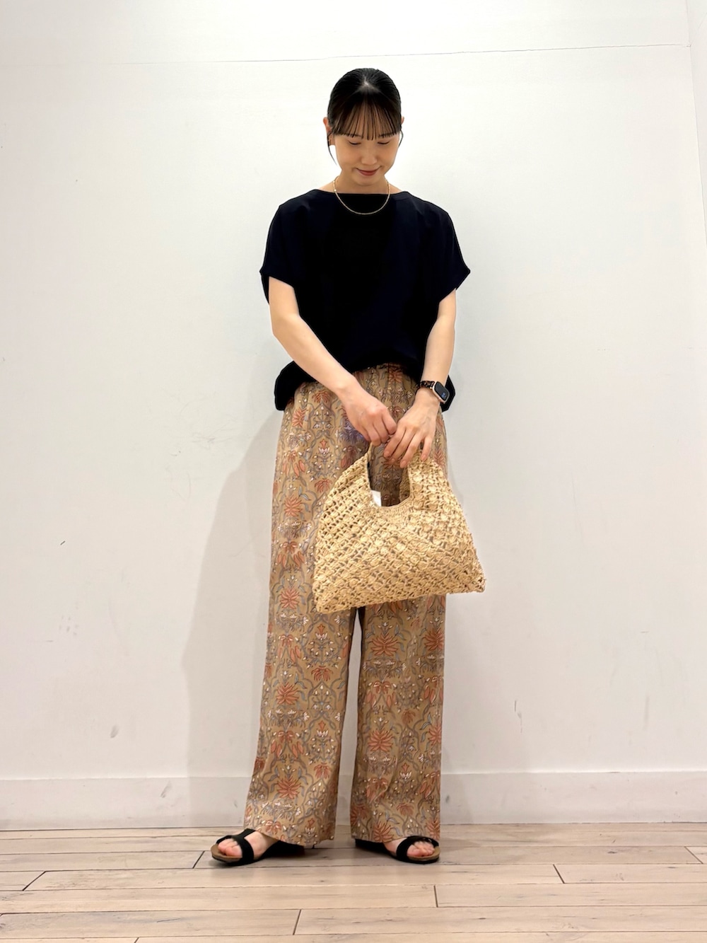 ブルー系のTシャツ/カットソー、ベージュ系のハンドバッグ、ベージュ系のその他パンツを着用したレディースの夏コーディネートの2枚目の写真