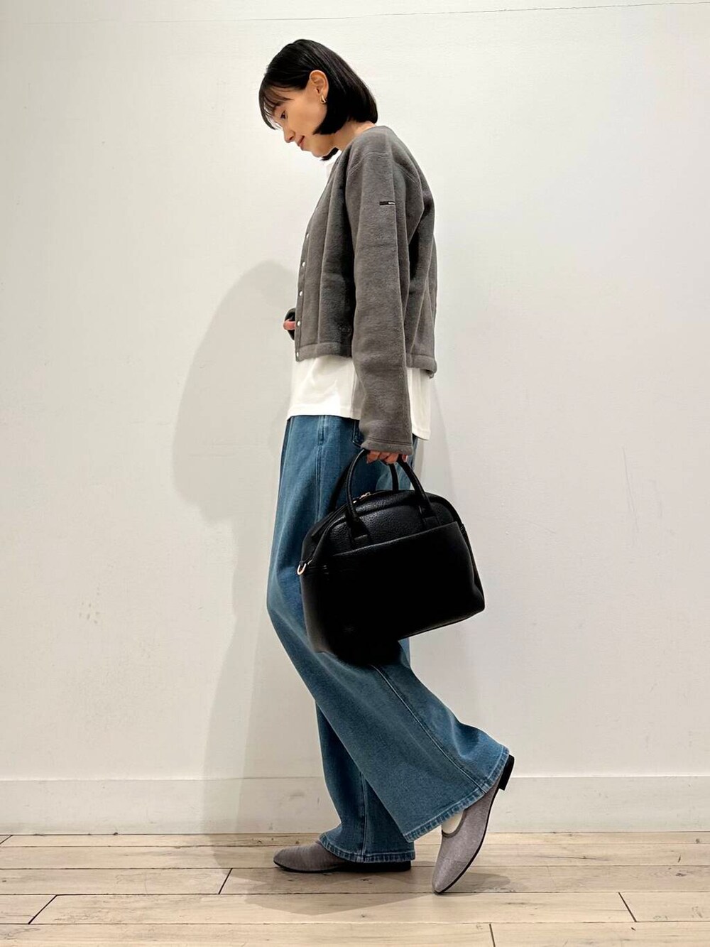 ブラック系のボストンバッグ、グレー系のバレエシューズ、グレー系のカーディガン/ボレロを着用したレディースの秋コーディネートの2枚目の写真