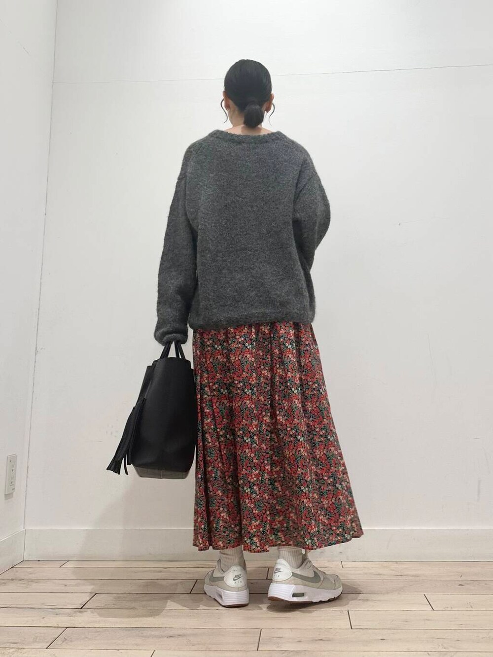 ブラック系のトートバッグ、グレー系のニット/セーター、ホワイト系のスニーカーを着用したレディースの冬コーディネートの3枚目の写真