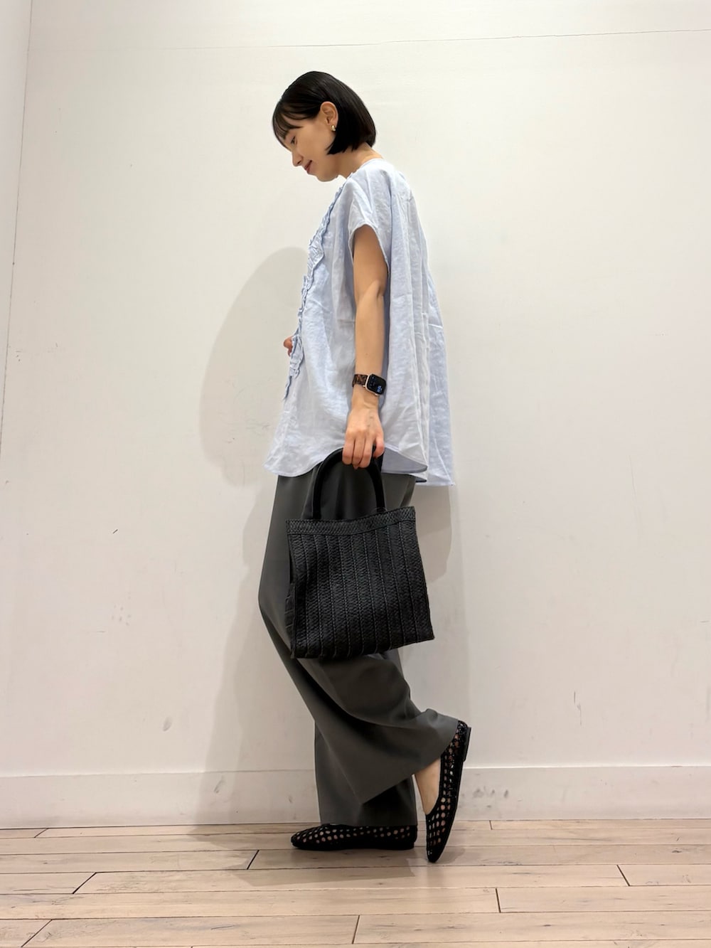 ブルー系のシャツ/ブラウス、グレー系のその他パンツ、ブラック系のハンドバッグを着用したレディースの春コーディネートの3枚目の写真