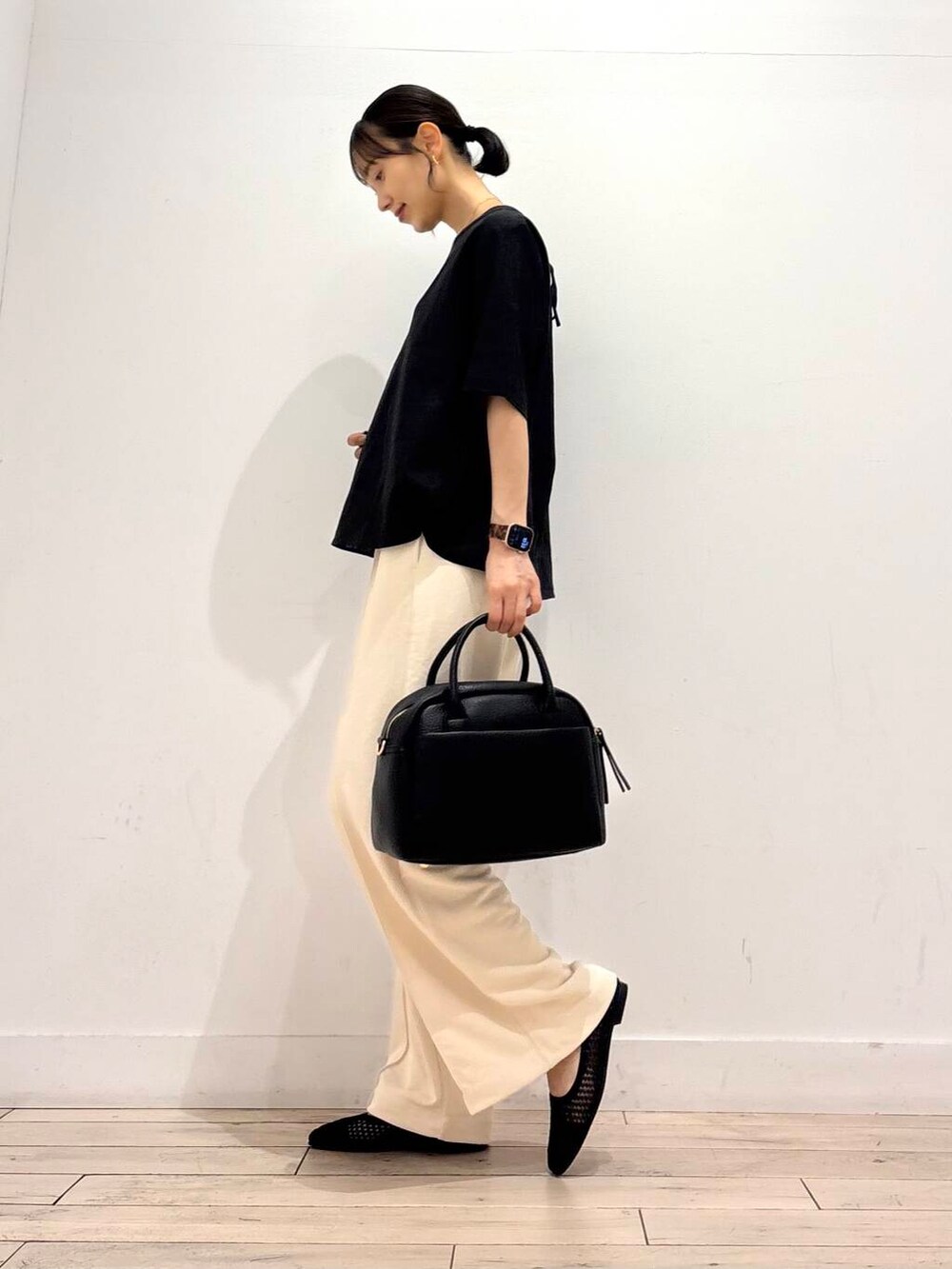 ブラック系のボストンバッグ、ブラック系のバレエシューズ、ブラック系のシャツ/ブラウスを着用したレディースの夏コーディネートの4枚目の写真