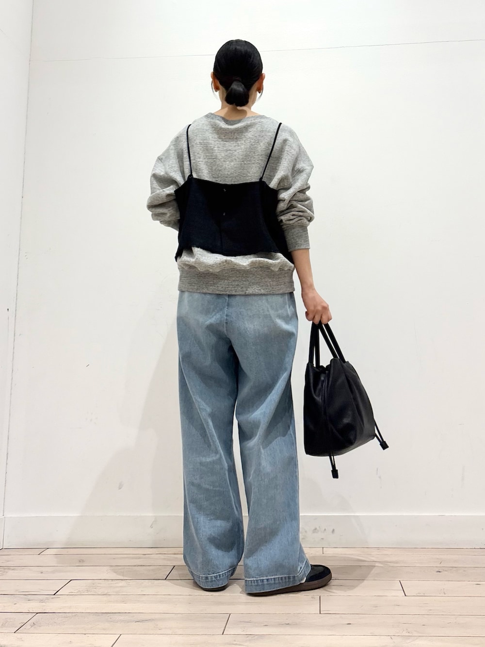 グレー系のスウェット、ブルー系のデニムパンツ、ブラック系のショルダーバッグを着用したレディースの春コーディネートの3枚目の写真