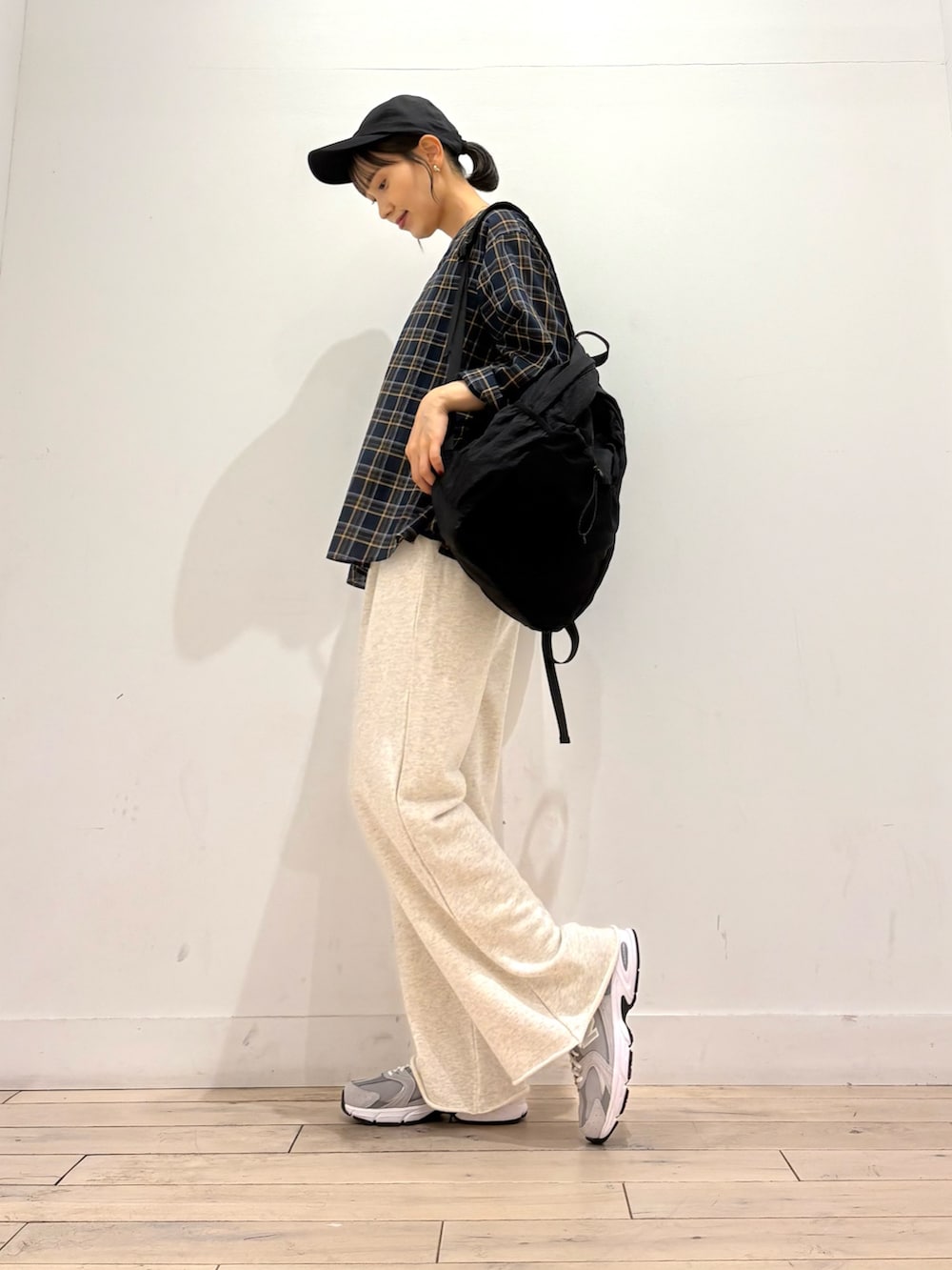 ベージュ系のその他パンツ、ブラック系のバックパック/リュック、グレー系のスニーカーを着用したレディースの秋コーディネートの2枚目の写真