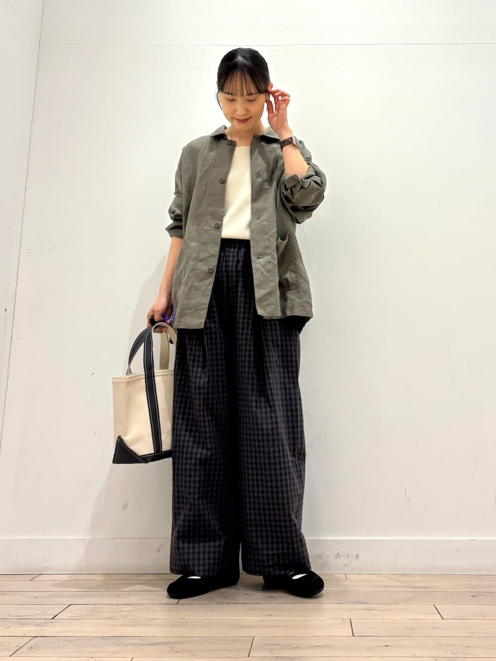 ホワイト系のタンクトップ、グレー系のカバーオール、グレー系のトートバッグを着用したレディースの春コーディネートの3枚目の写真