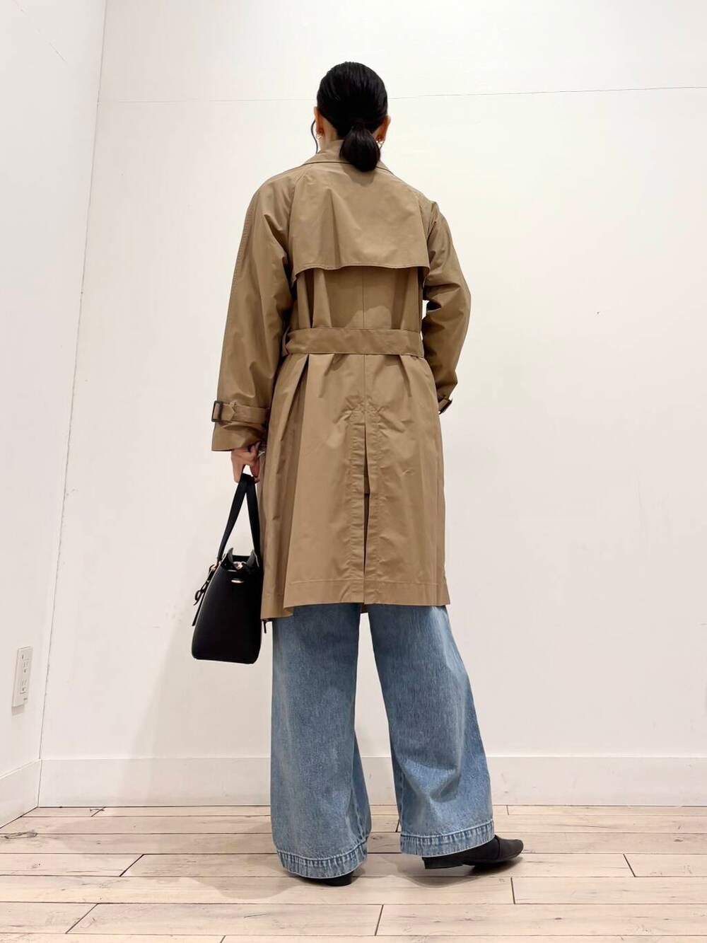 ブルー系のデニムパンツ、ベージュ系のトレンチコート、ブラック系のローファーを着用したレディースの春コーディネートの3枚目の写真