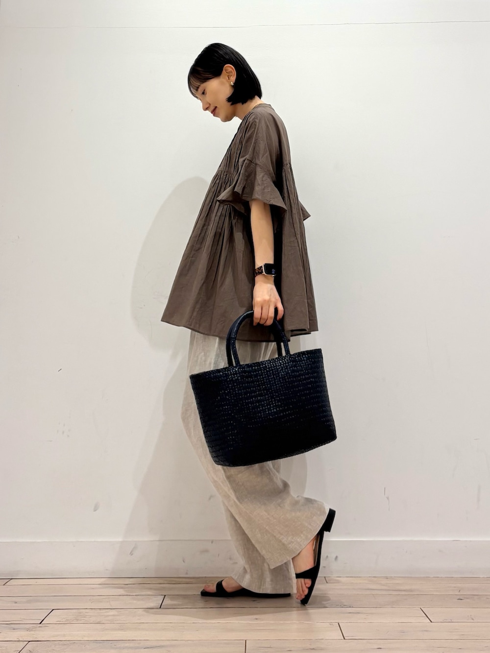 ブルー系のトートバッグ、ベージュ系のその他パンツ、ブラック系のサンダルを着用したレディースの春コーディネートの3枚目の写真