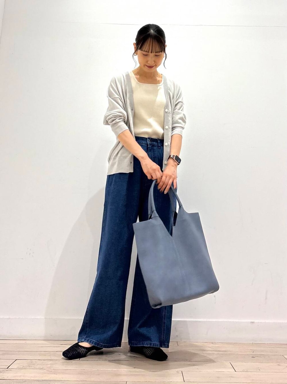 ブルー系のデニムパンツ、ブルー系のトートバッグ、グレー系のカーディガン/ボレロを着用したレディースの夏コーディネートの2枚目の写真