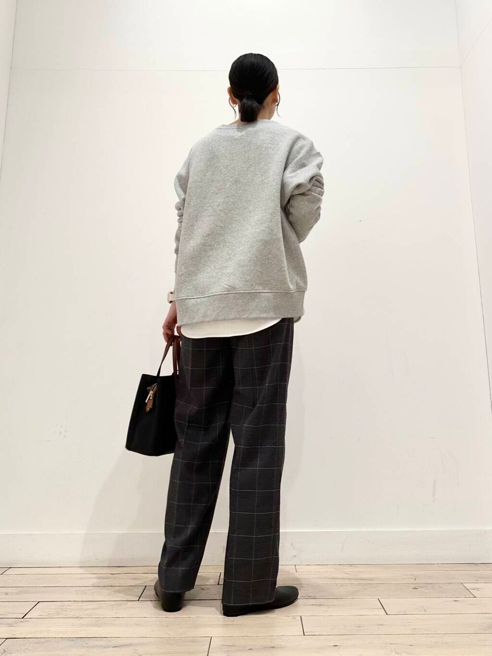 ブラック系のトートバッグ、グレー系のスウェット、ホワイト系のTシャツ/カットソーを着用したレディースの冬コーディネートの3枚目の写真