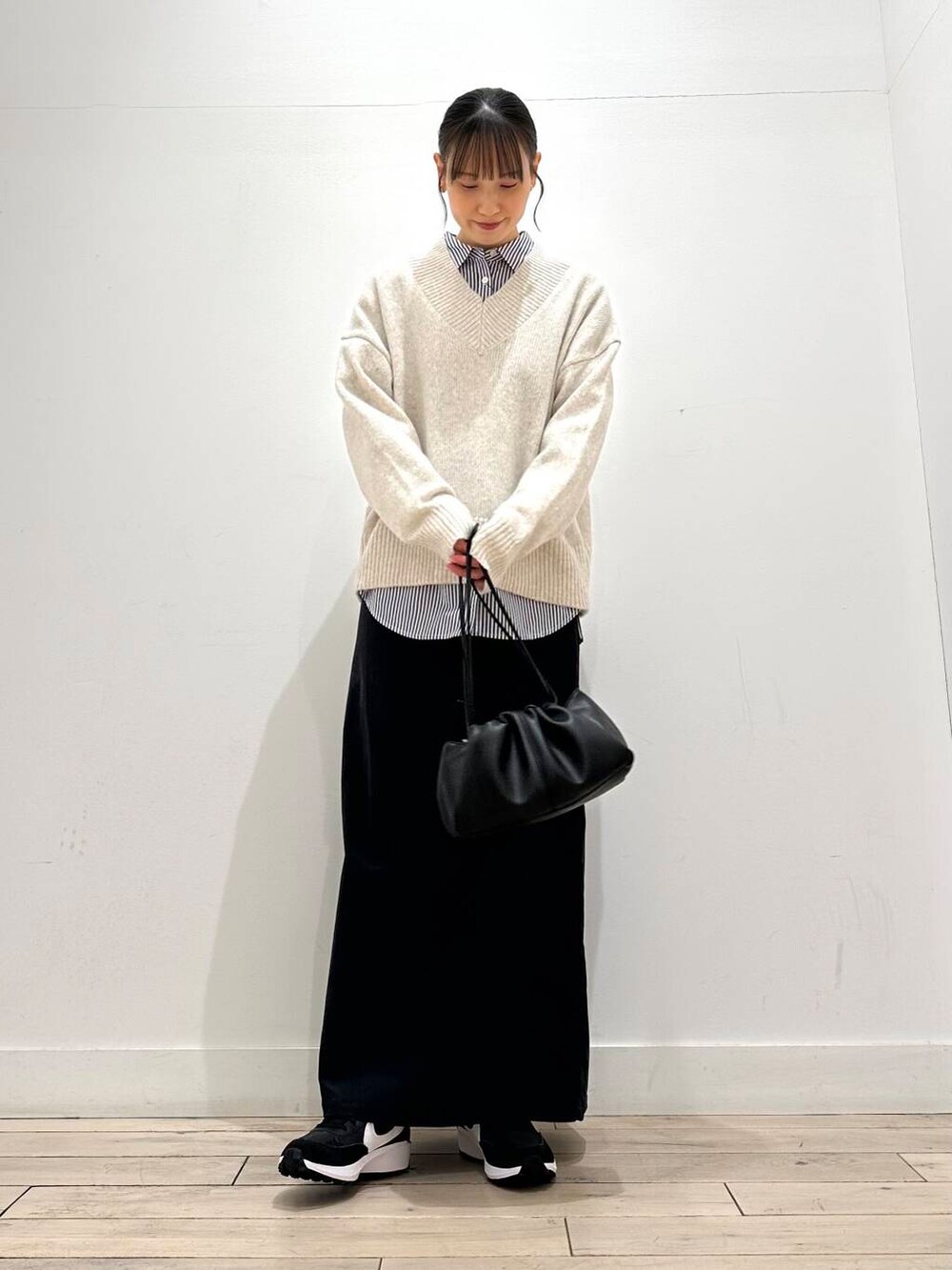 ブルー系のシャツ/ブラウス、グレー系のスカート、ホワイト系のニット/セーターを着用したレディースの冬コーディネートの2枚目の写真