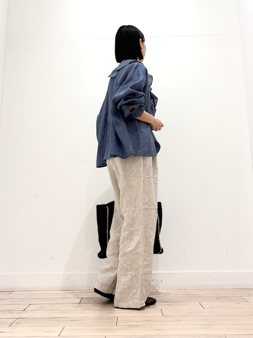 ブルー系のシャツ/ブラウス、ベージュ系のその他パンツ、ブラック系のトートバッグを着用したレディースの春コーディネートの4枚目の写真