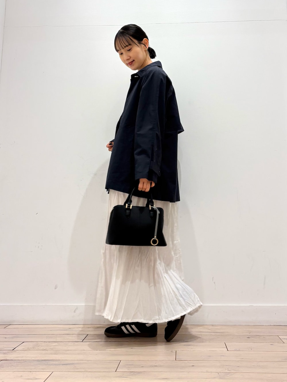 ブラック系のTシャツ/カットソー、ブラック系のスニーカー、グレー系のスカートを着用したレディースの春コーディネートの2枚目の写真