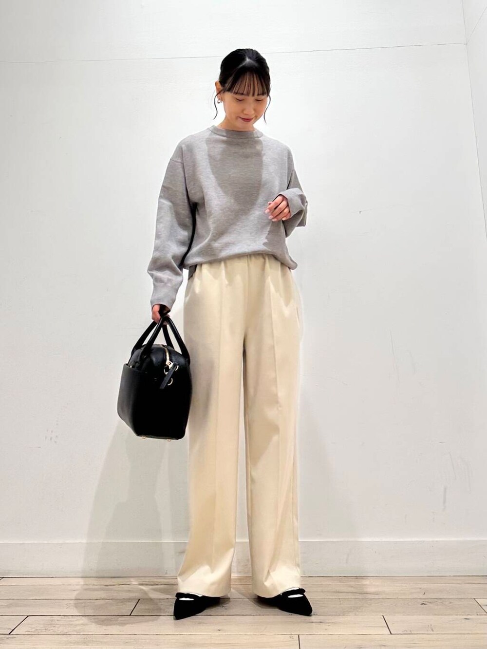 ブラック系のボストンバッグ、ブラック系のパンプス、ブルー系のステンカラーコートを着用したレディースの冬コーディネートの5枚目の写真