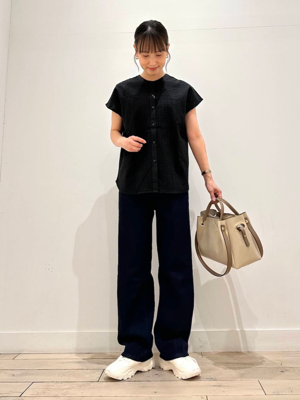 ホワイト系のトートバッグ、ホワイト系のスニーカー、ブラック系のシャツ/ブラウスを着用したレディースの夏コーディネートの4枚目の写真