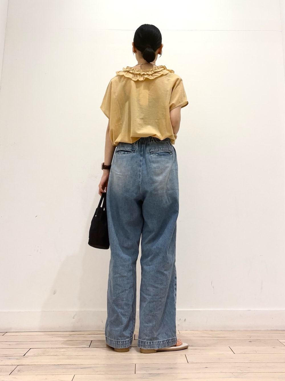 ブルー系のデニムパンツ、グレー系のサンダル、イエロー系のシャツ/ブラウスを着用したレディースの夏コーディネートの4枚目の写真