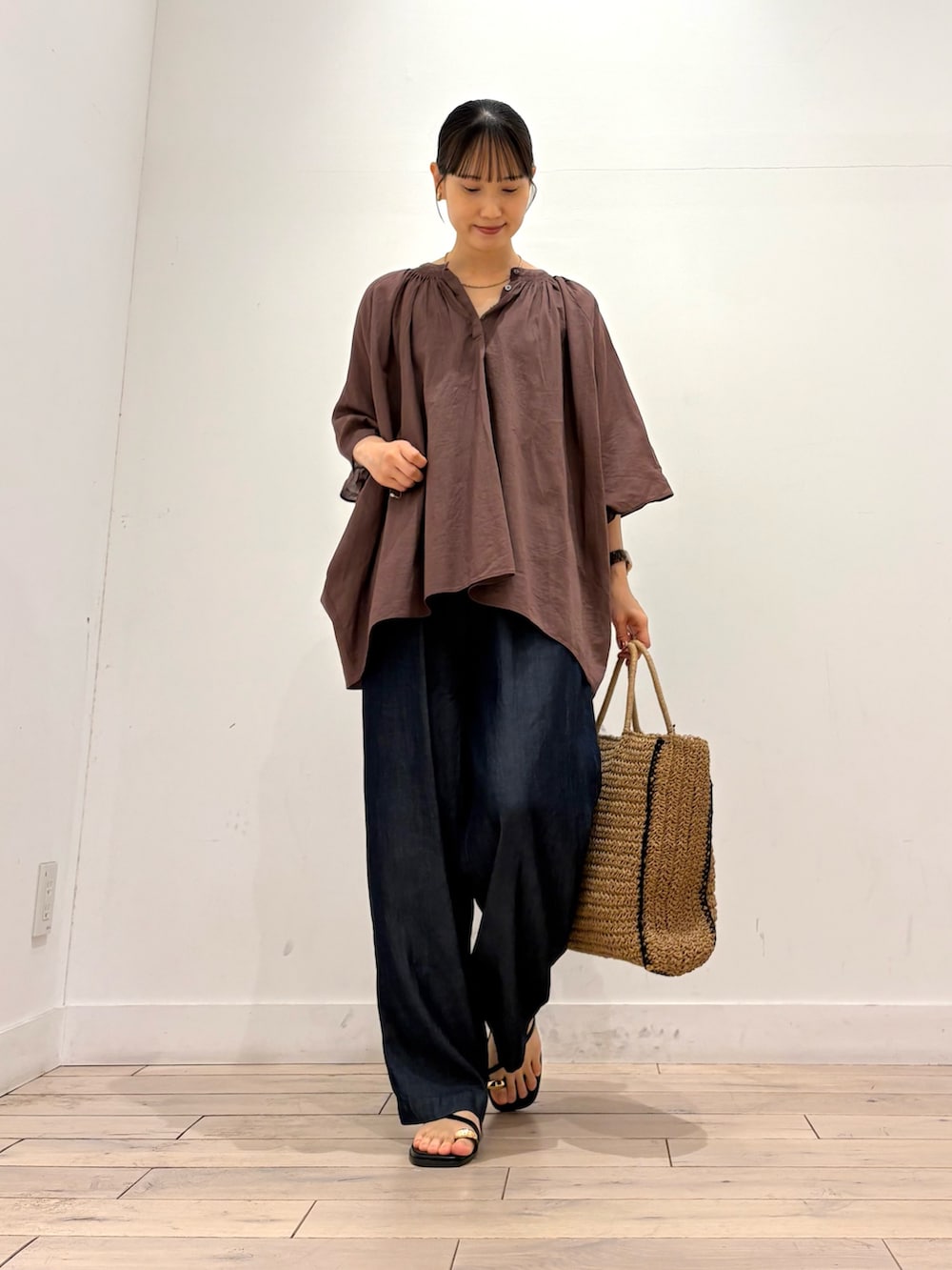 ブラウン系のシャツ/ブラウス、ブルー系のデニムパンツ、ベージュ系のトートバッグを着用したレディースの夏コーディネートの2枚目の写真