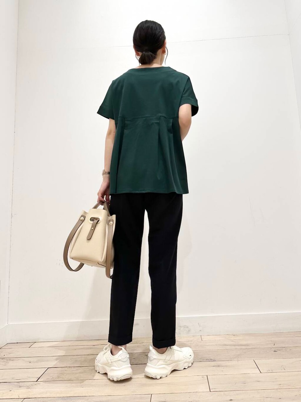 ホワイト系のトートバッグ、ホワイト系のスニーカー、グリーン系のTシャツ/カットソーを着用したレディースの夏コーディネートの3枚目の写真