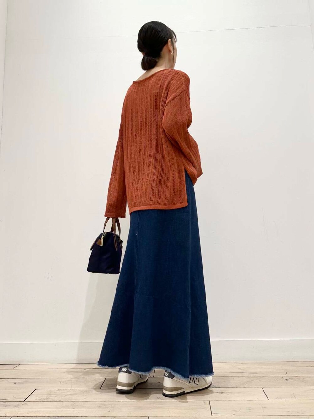 ブルー系のトートバッグ、ホワイト系のスニーカー、オレンジ系のニット/セーターを着用したレディースの夏コーディネートの4枚目の写真