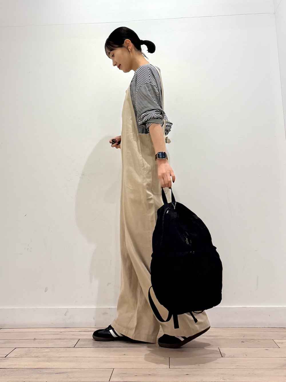 ブラック系のTシャツ/カットソー、ブラック系のバックパック/リュック、ブラック系のスニーカーを着用したレディースの春コーディネートの4枚目の写真