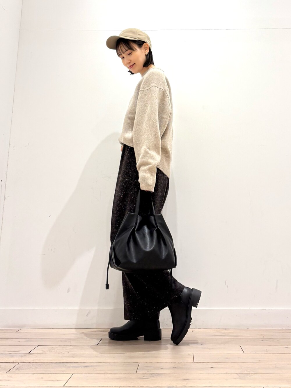 ブルー系のピーコート、ベージュ系のニット/セーター、ブラウン系のその他パンツを着用したレディースの冬コーディネートの3枚目の写真