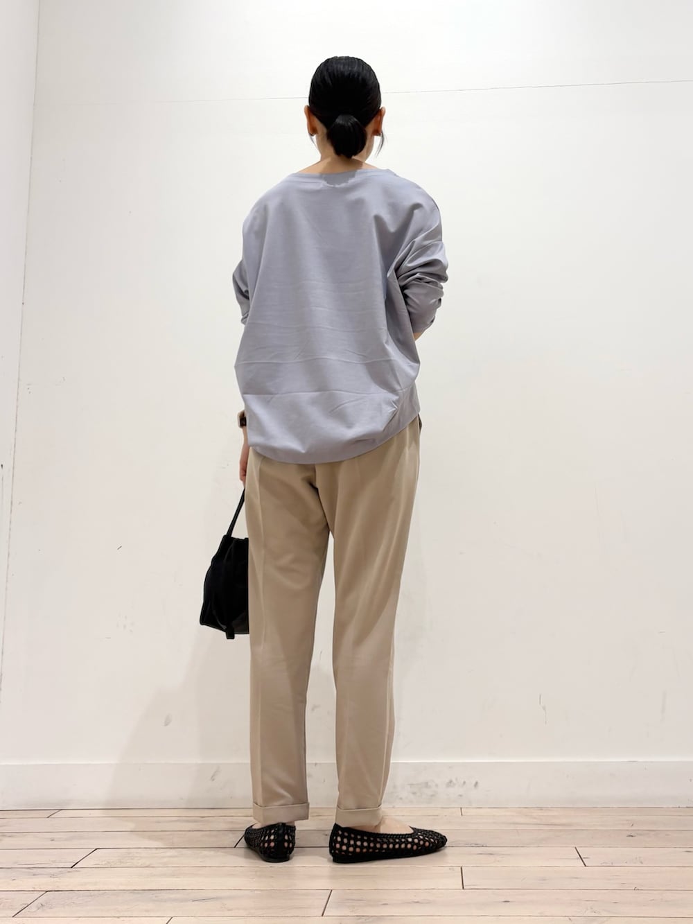 パープル系のTシャツ/カットソー、ベージュ系のその他パンツ、ブラック系のショルダーバッグを着用したレディースの春コーディネートの4枚目の写真