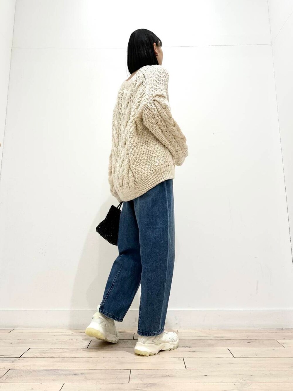 ブラック系のショルダーバッグ、ホワイト系のスニーカー、ブラック系のその他アウターを着用したレディースの冬コーディネートの4枚目の写真