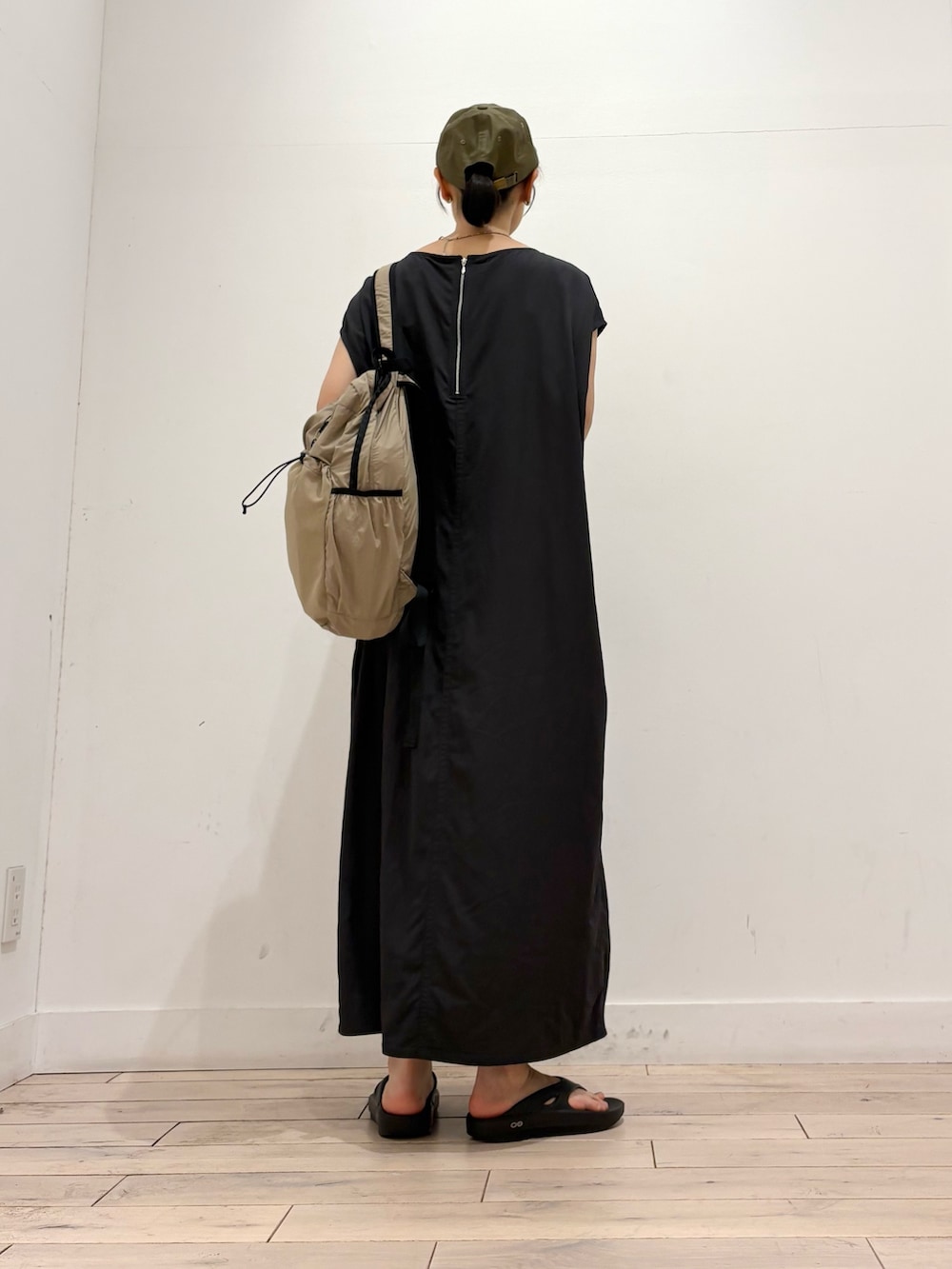 グレー系のワンピース、ベージュ系のバックパック/リュック、ブラック系のサンダルを着用したレディースの夏コーディネートの4枚目の写真