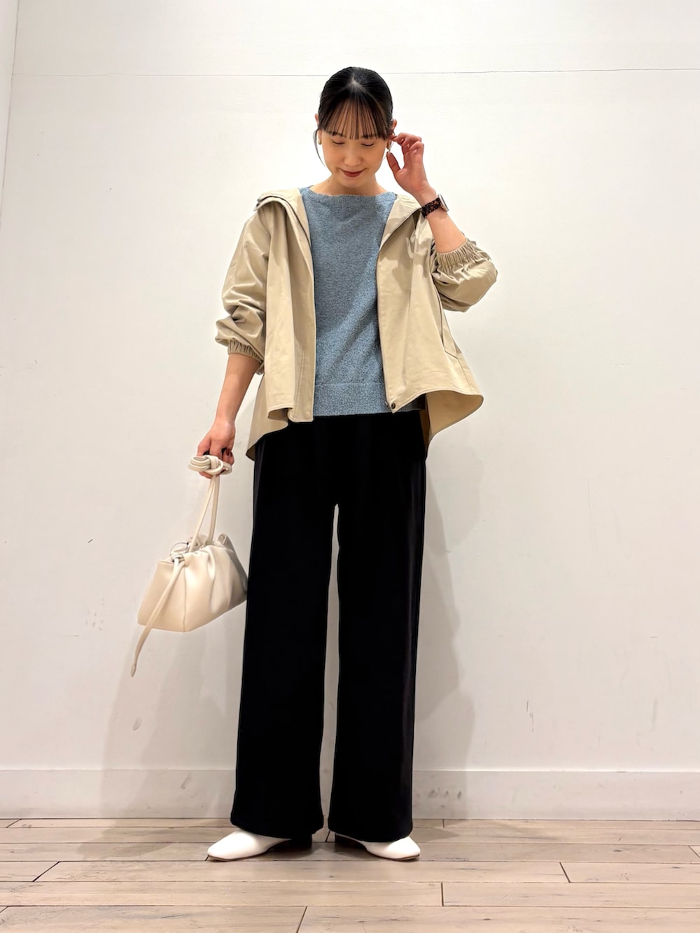 ベージュ系のその他アウター、ブラック系のその他パンツ、ホワイト系のショルダーバッグを着用したレディースの春コーディネートの2枚目の写真