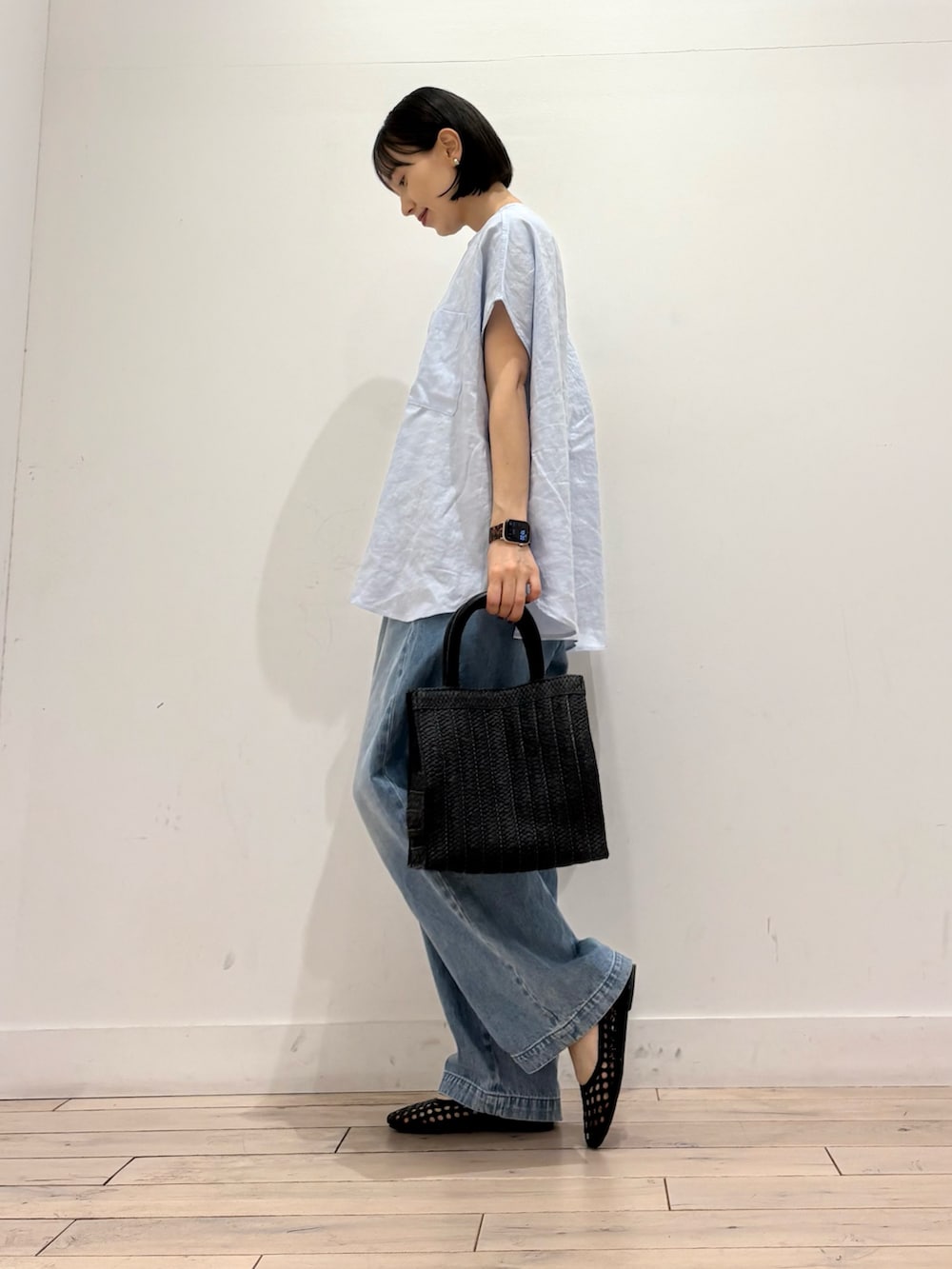 ブルー系のシャツ/ブラウス、ブルー系のデニムパンツ、ブラック系のハンドバッグを着用したレディースの春コーディネートの3枚目の写真