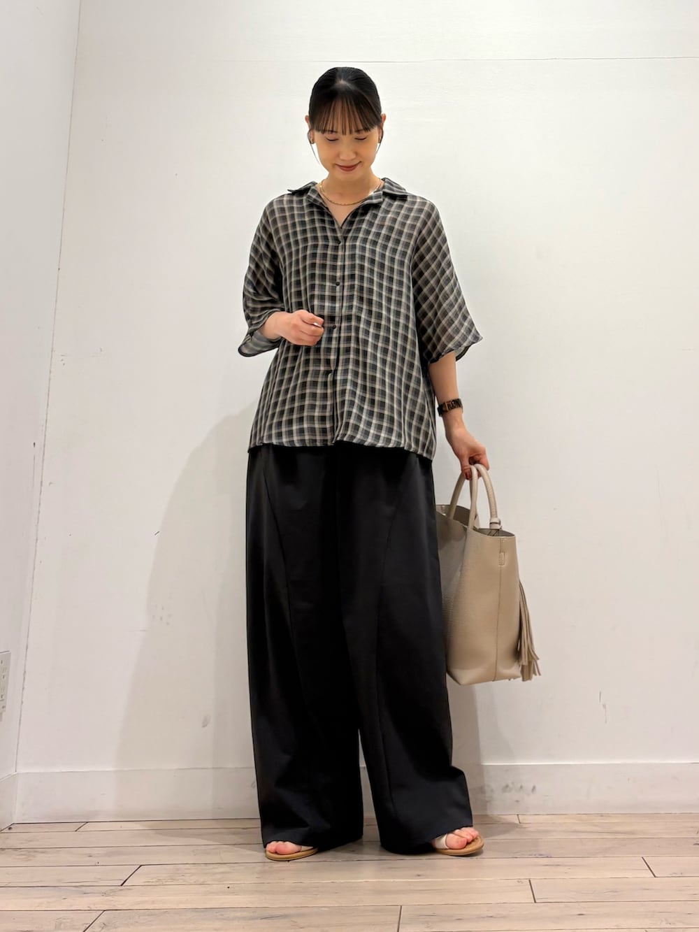 ホワイト系のトートバッグ、グレー系のその他パンツ、ベージュ系のシャツ/ブラウスを着用したレディースの夏コーディネートの2枚目の写真