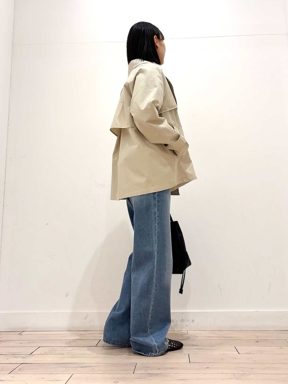 ベージュ系のトレンチコート、ブルー系のニット/セーター、ブラック系のサンダルを着用したレディースの春コーディネートの5枚目の写真