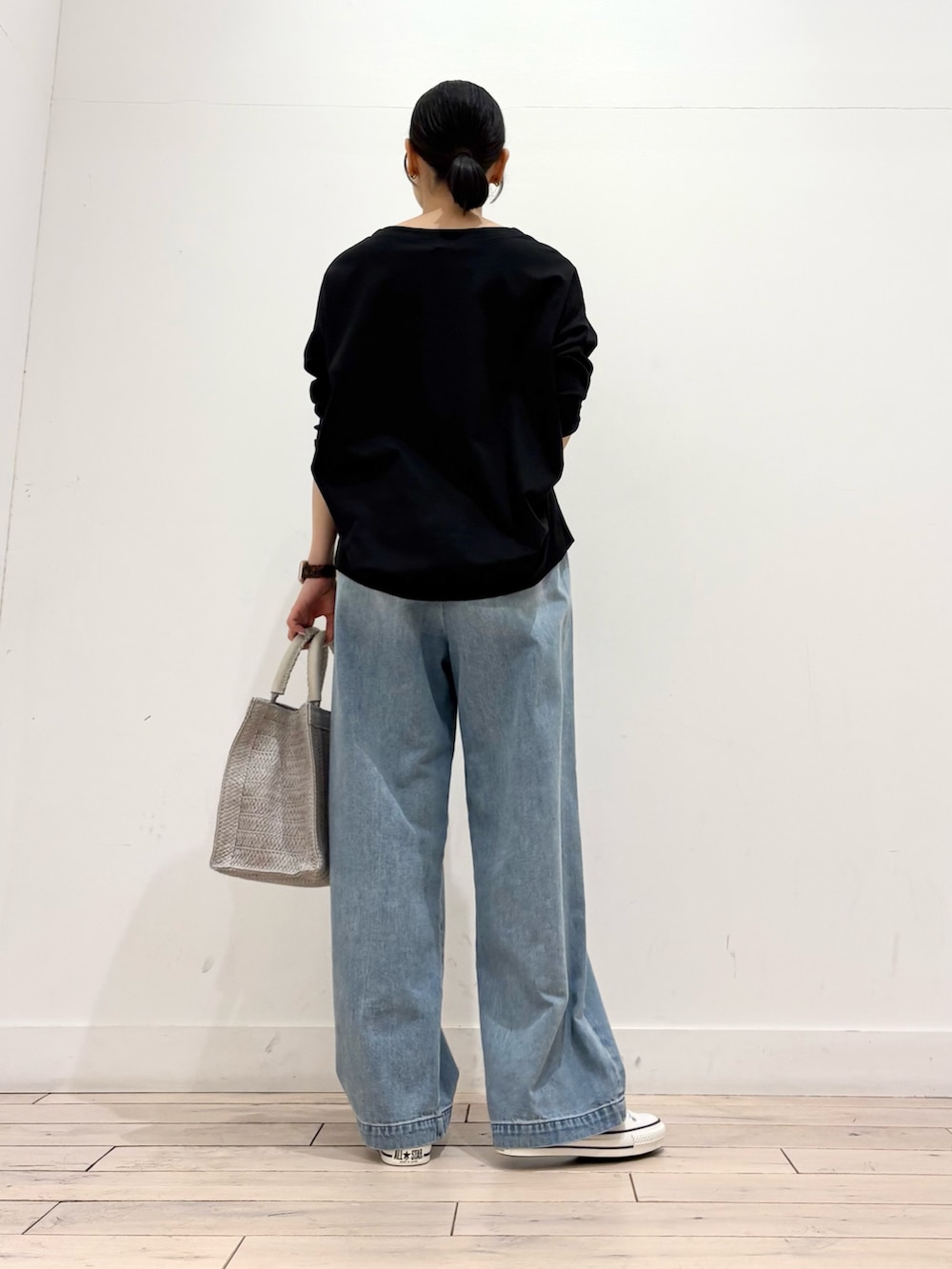 ブラック系のTシャツ/カットソー、グレー系のハンドバッグ、ブルー系のデニムパンツを着用したレディースの春コーディネートの4枚目の写真