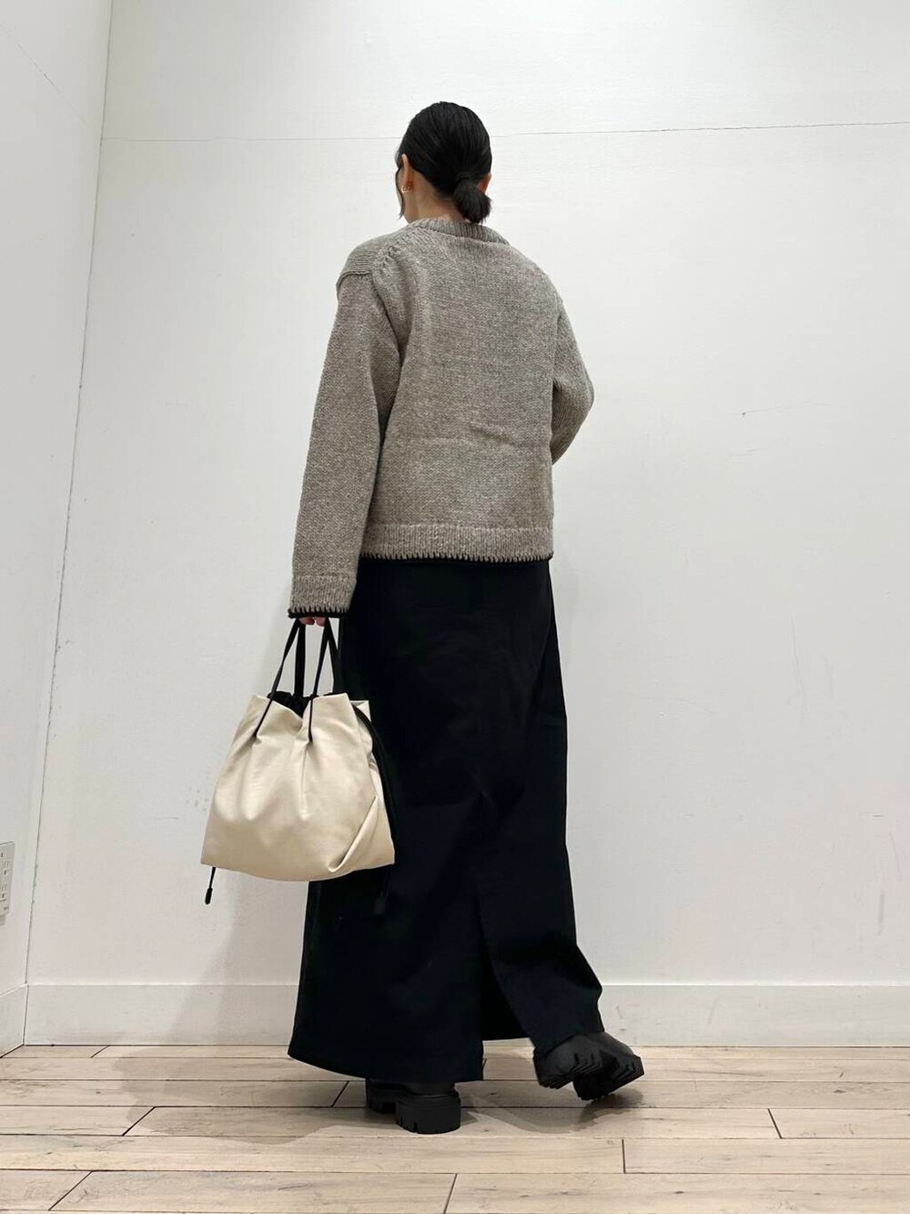 ホワイト系のショルダーバッグ、グレー系のニット/セーター、ブラック系のスカートを着用したレディースの冬コーディネートの5枚目の写真