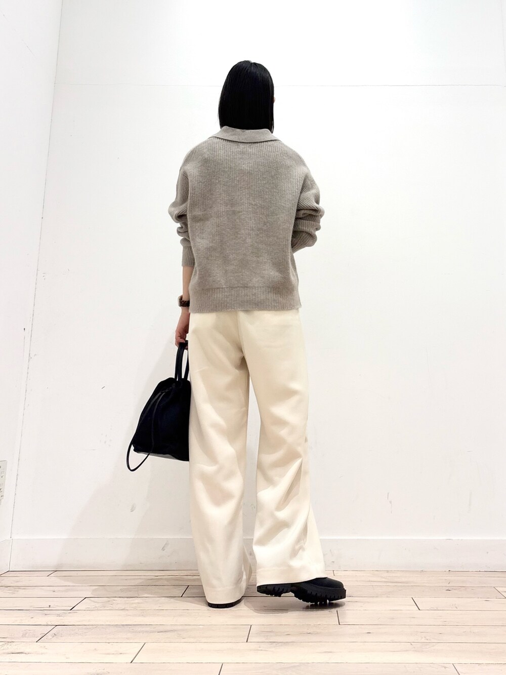 ベージュ系のニット/セーター、ブラック系のブーツ、ブラック系のショルダーバッグを着用したレディースの秋コーディネートの3枚目の写真