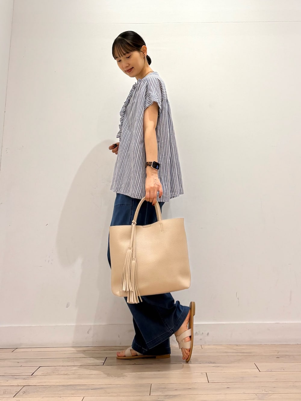 ブルー系のシャツ/ブラウス、ブルー系のデニムパンツ、ホワイト系のトートバッグを着用したレディースの夏コーディネートの3枚目の写真