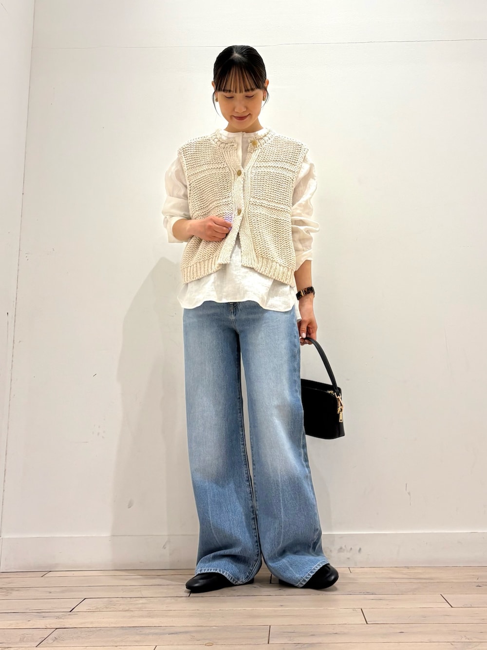 ホワイト系のシャツ/ブラウス、ホワイト系のベスト、ブラック系のショルダーバッグを着用したレディースの春コーディネートの2枚目の写真