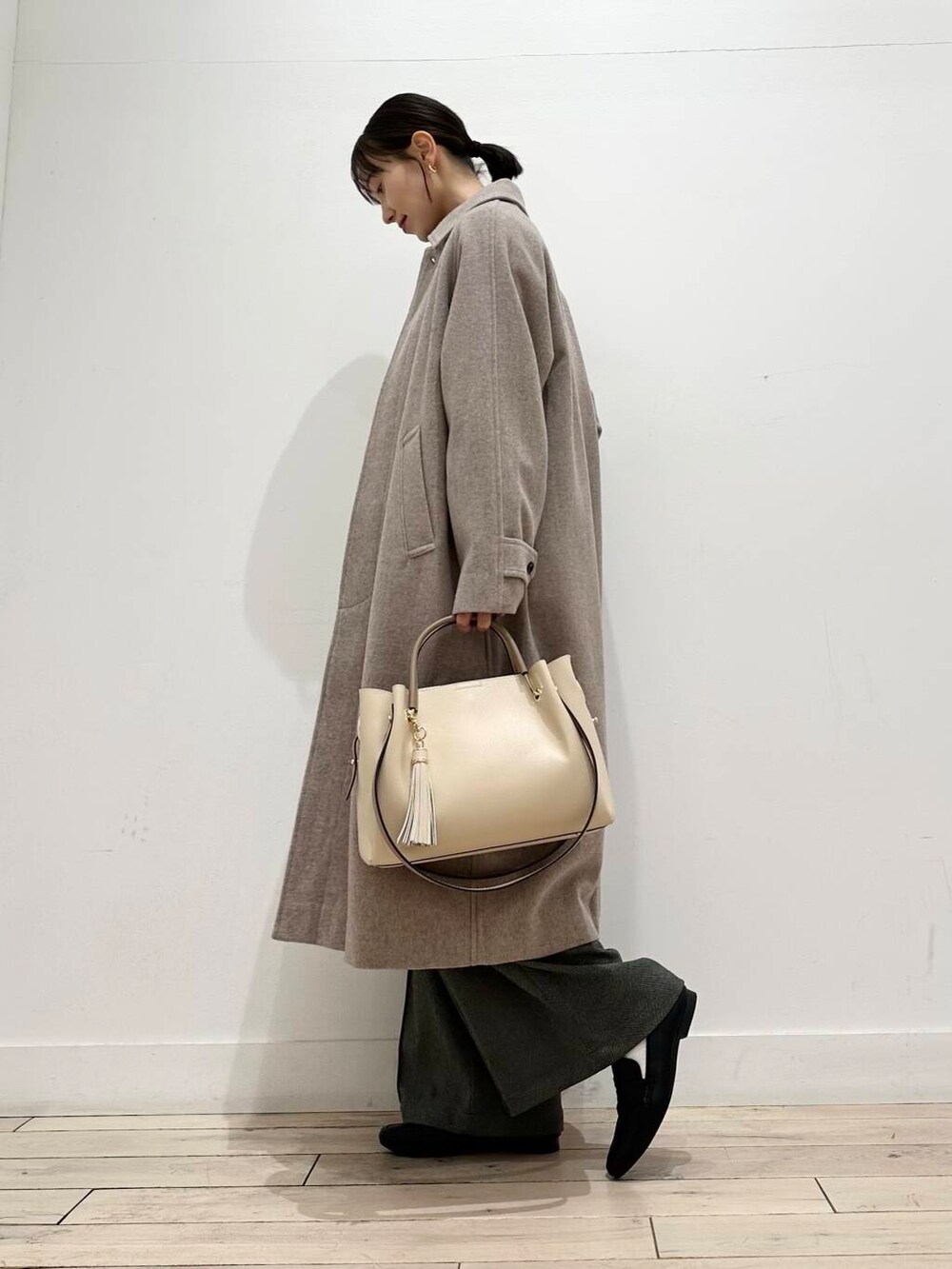 ホワイト系のトートバッグ、グレー系のその他アウター、ホワイト系のTシャツ/カットソーを着用したレディースの冬コーディネートの2枚目の写真