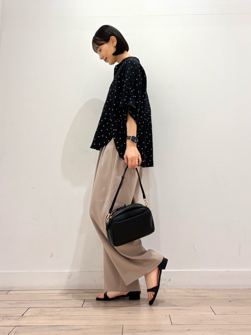 ブラック系のシャツ/ブラウス、ベージュ系のその他パンツ、ブラック系のショルダーバッグを着用したレディースの春コーディネートの3枚目の写真