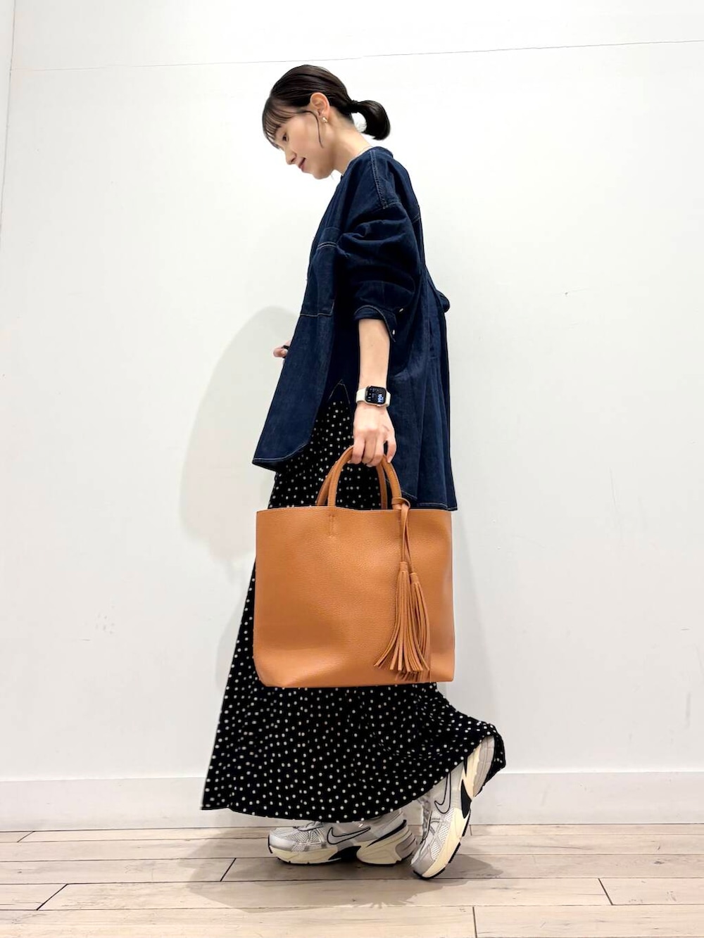 イエロー系のトートバッグ、ホワイト系のスニーカー、グレー系のTシャツ/カットソーを着用したレディースの冬コーディネートの3枚目の写真