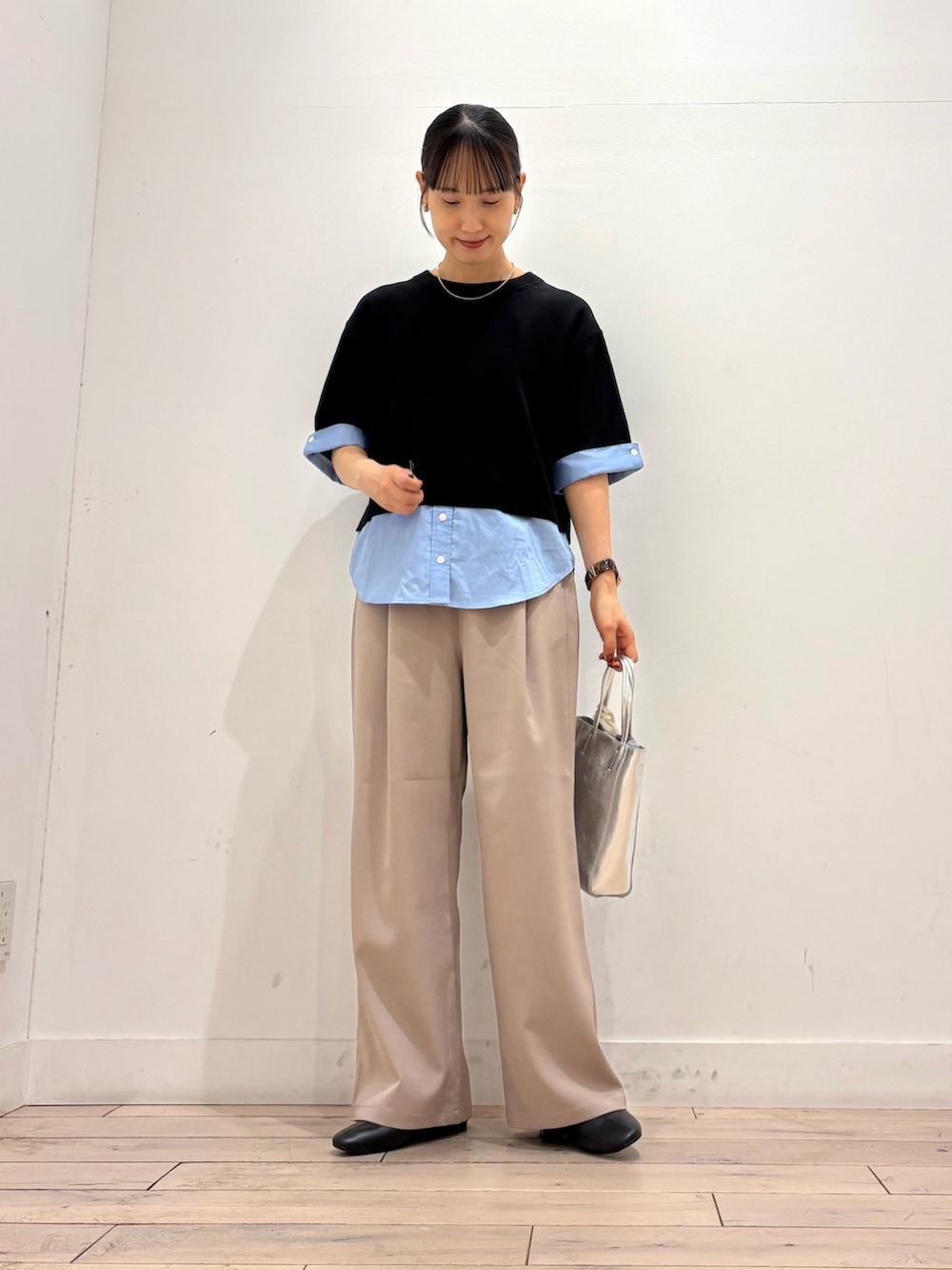 ブラック系のニット/セーター、ベージュ系のその他パンツ、シルバー系のトートバッグを着用したレディースの夏コーディネートの2枚目の写真