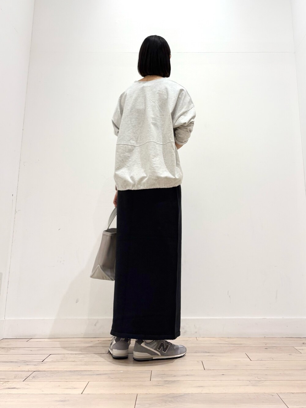 ブラック系のスカート、グレー系のトートバッグ、グレー系のスニーカーを着用したレディースの秋コーディネートの3枚目の写真