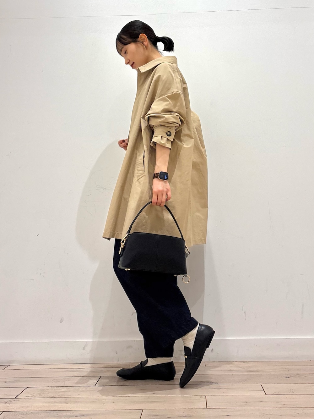 ブルー系のTシャツ/カットソー、ベージュ系のステンカラーコート、ブルー系のデニムパンツを着用したレディースの春コーディネートの3枚目の写真