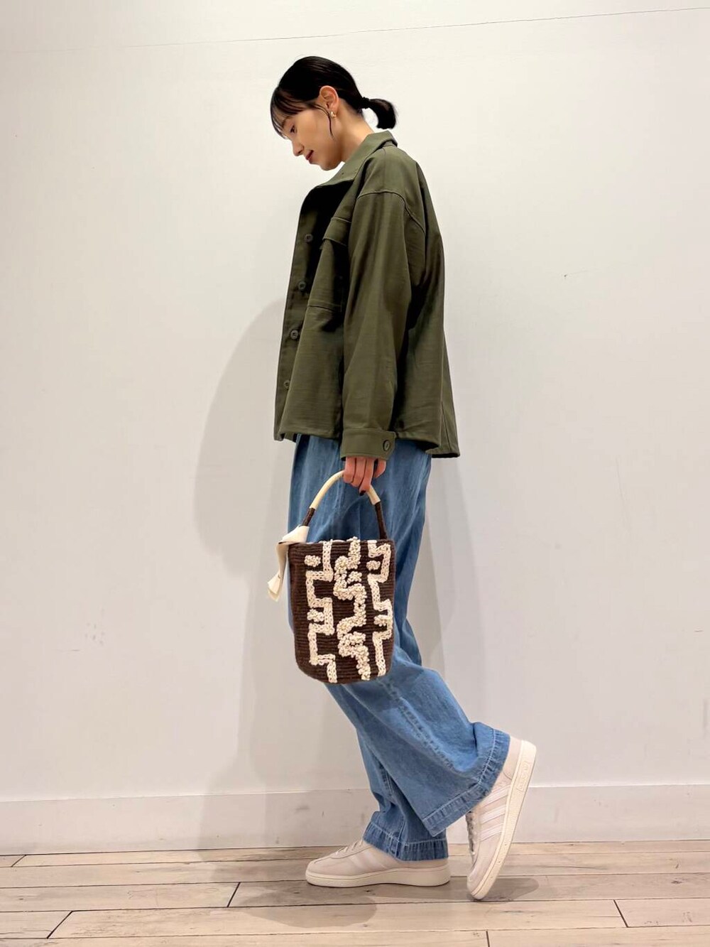 グリーン系のミリタリージャケット、ブルー系のデニムパンツ、ブルー系のカーディガン/ボレロを着用したレディースの春コーディネートの6枚目の写真