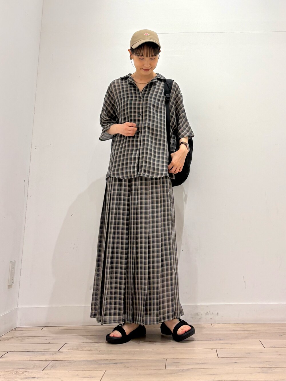 ベージュ系のシャツ/ブラウス、ベージュ系のスカート、ブラック系のサンダルを着用したレディースの夏コーディネートの2枚目の写真