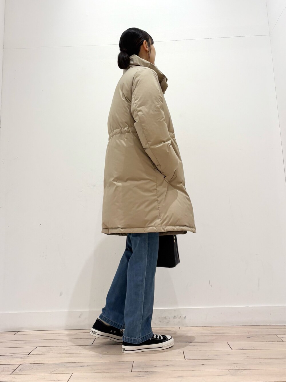 ベージュ系のダウンジャケット/コート、ベージュ系のTシャツ/カットソー、ブルー系のその他パンツを着用したレディースの冬コーディネートの4枚目の写真