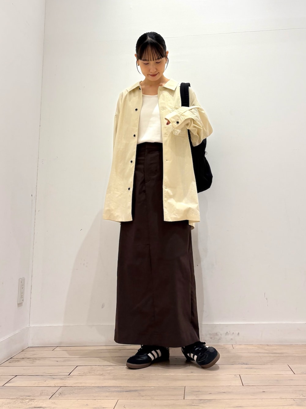 ホワイト系のタンクトップ、ホワイト系のシャツ/ブラウス、ブラック系のスニーカーを着用したレディースの夏コーディネートの2枚目の写真