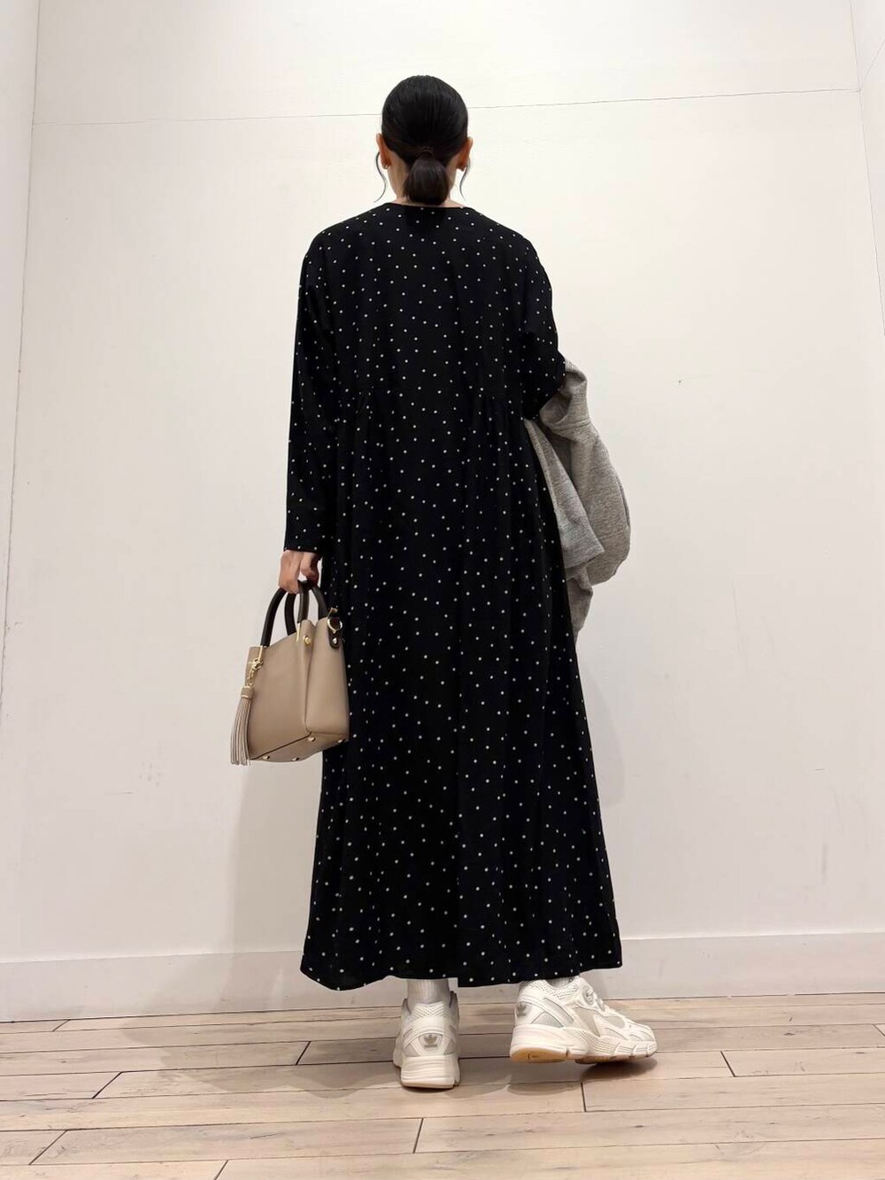 ベージュ系のトートバッグ、ブラック系のワンピース、グレー系のパーカーを着用したレディースの春コーディネートの5枚目の写真