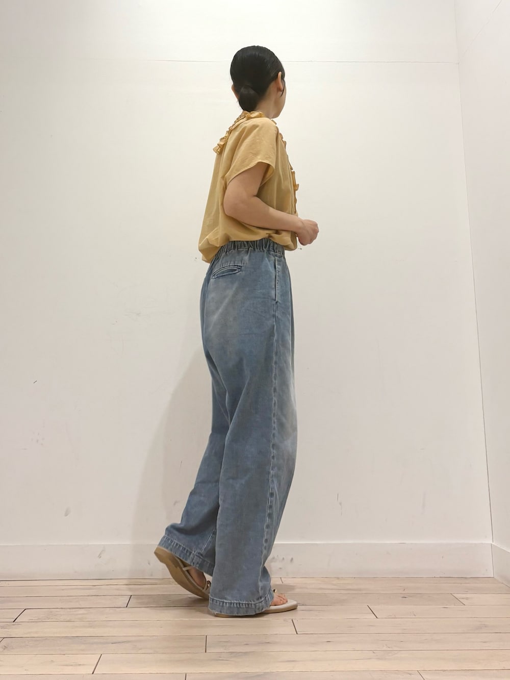 ブルー系のデニムパンツ、グレー系のサンダル、イエロー系のシャツ/ブラウスを着用したレディースの夏コーディネートの3枚目の写真