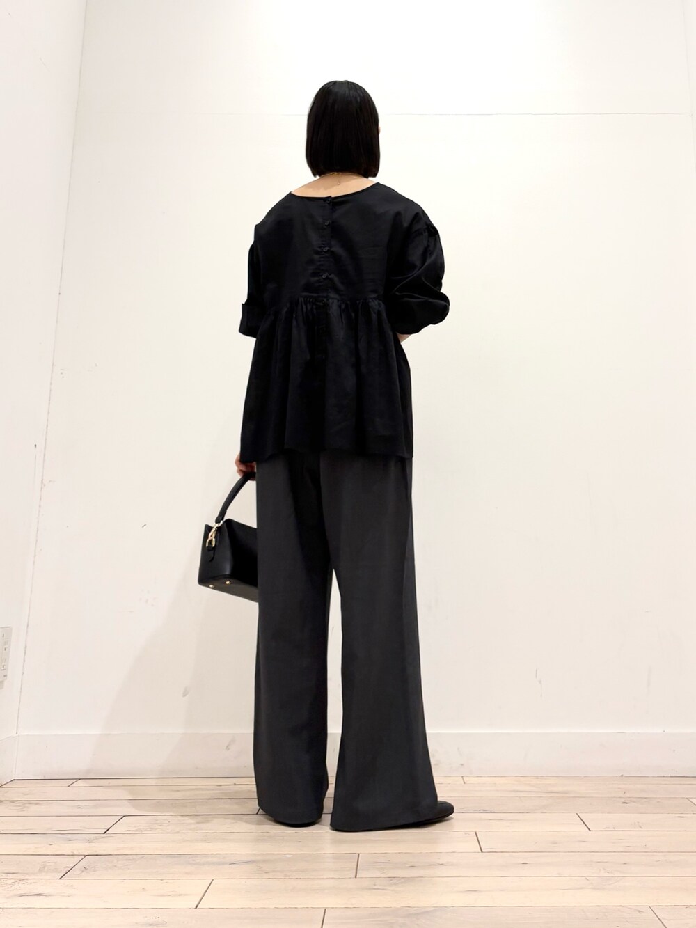 ブラック系のシャツ/ブラウス、グレー系のその他パンツ、ブラック系のショルダーバッグを着用したレディースの秋コーディネートの5枚目の写真