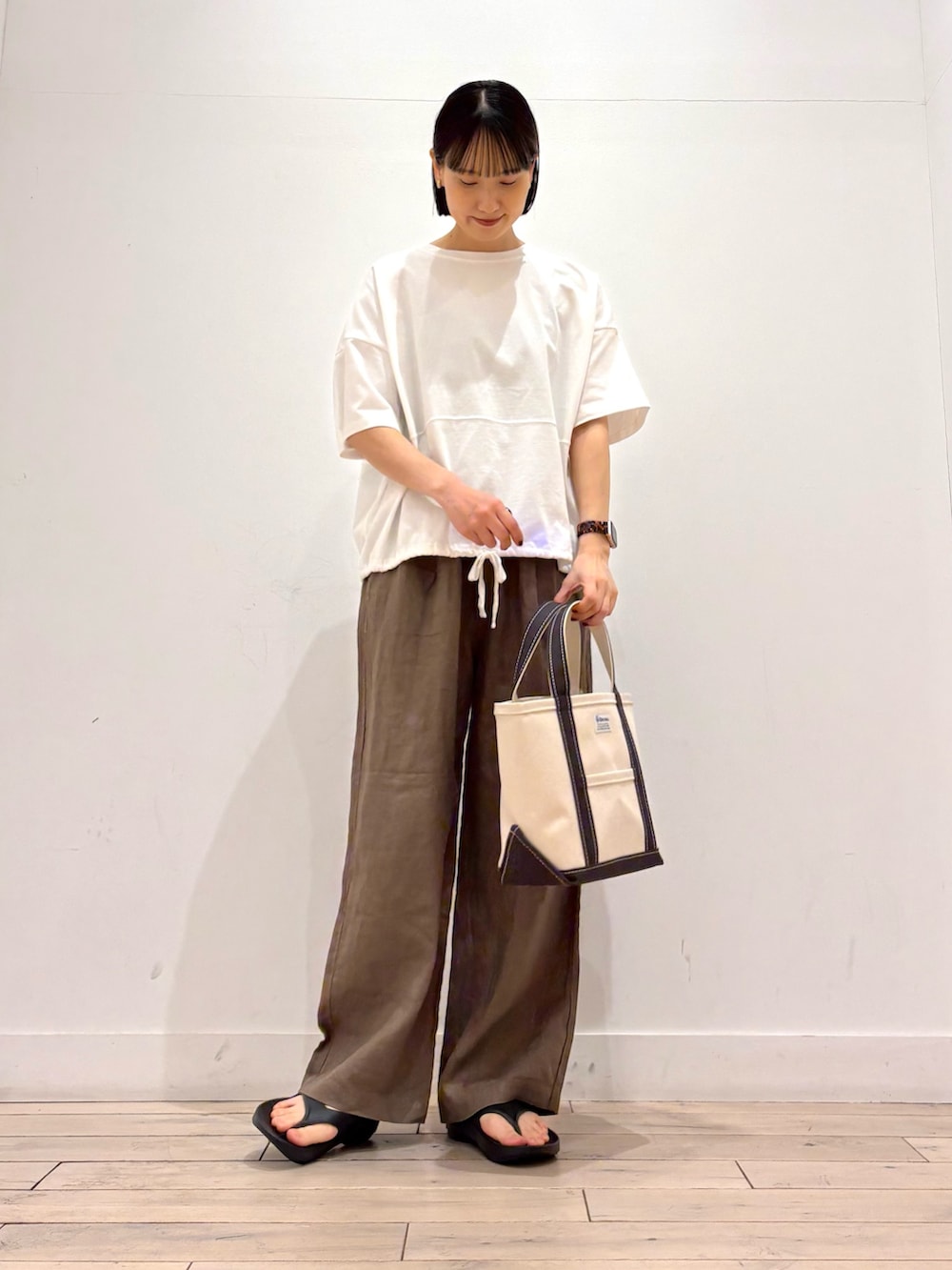ホワイト系のTシャツ/カットソー、グレー系のトートバッグ、ブラウン系のその他パンツを着用したレディースの春コーディネートの3枚目の写真