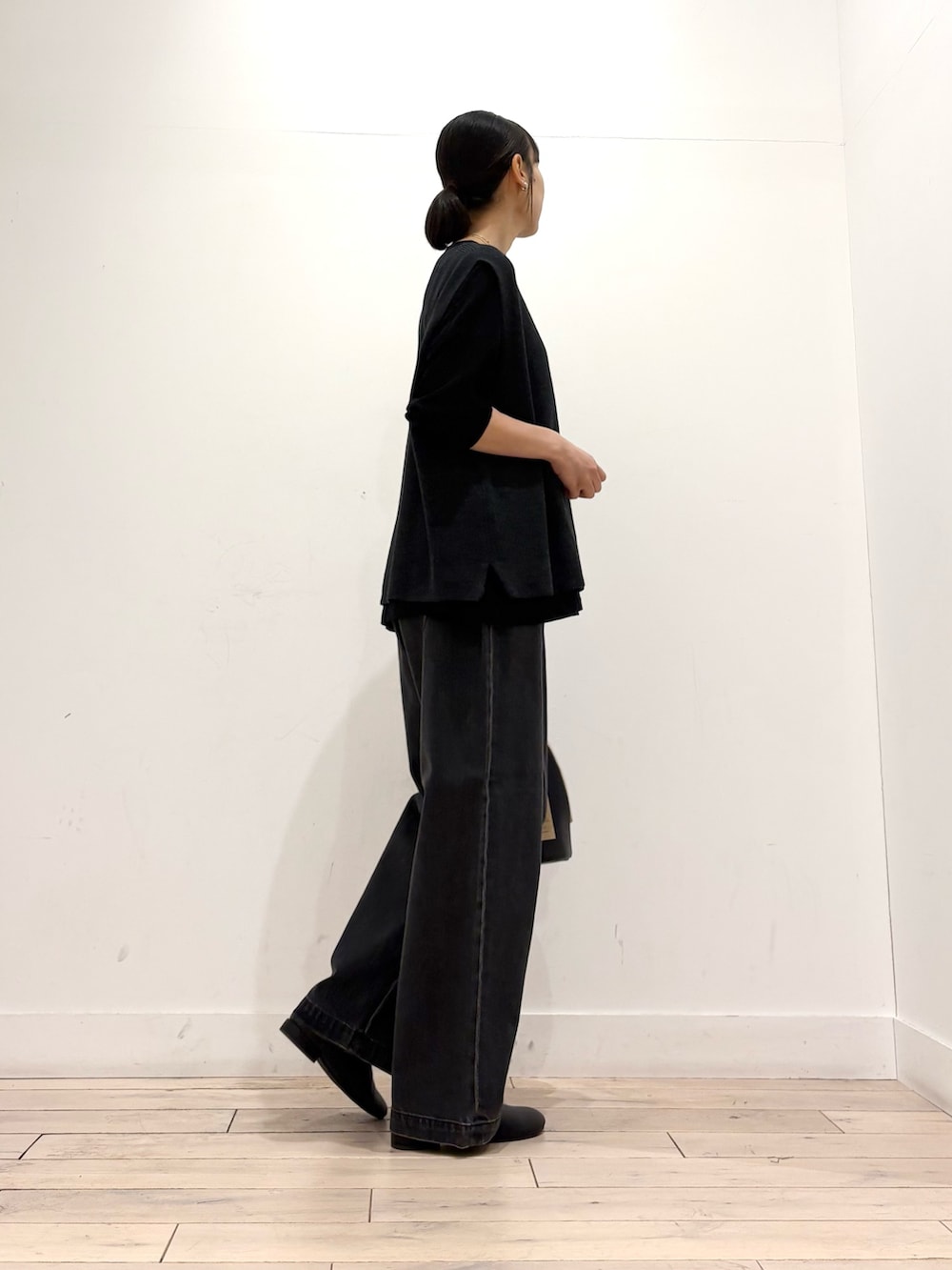 グレー系のベスト、ブラック系のTシャツ/カットソー、ブラック系のハンドバッグを着用したレディースの秋コーディネートの3枚目の写真